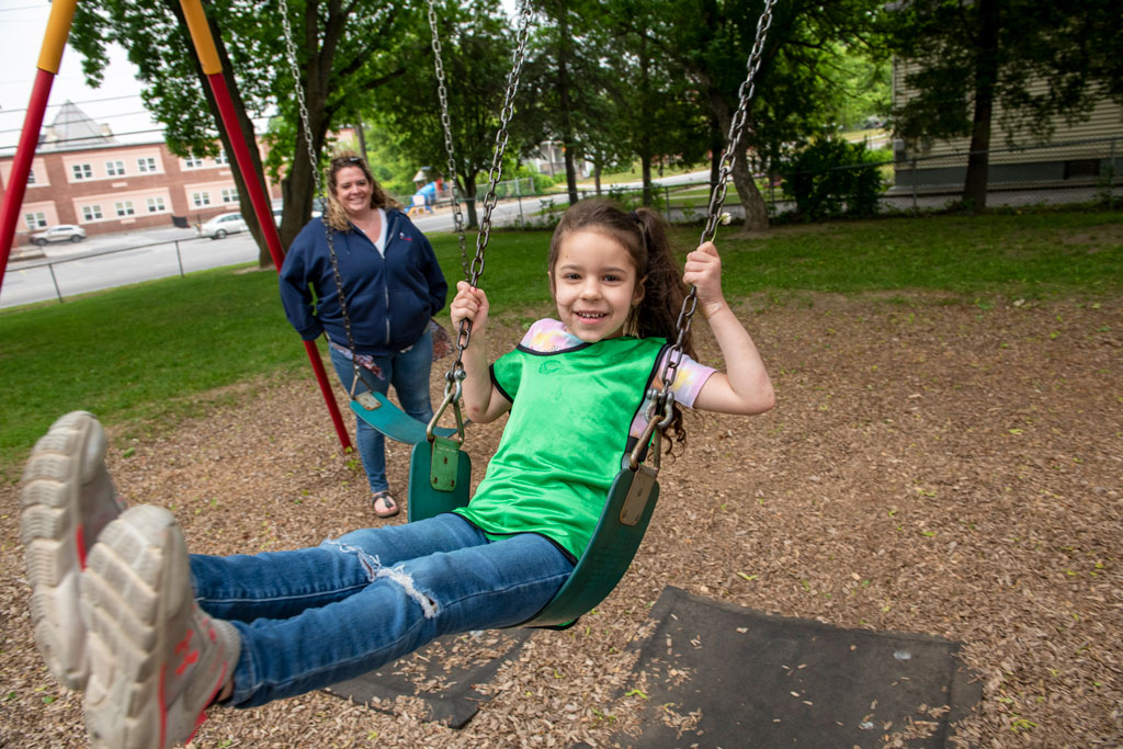 Student swinging with teacher supervising